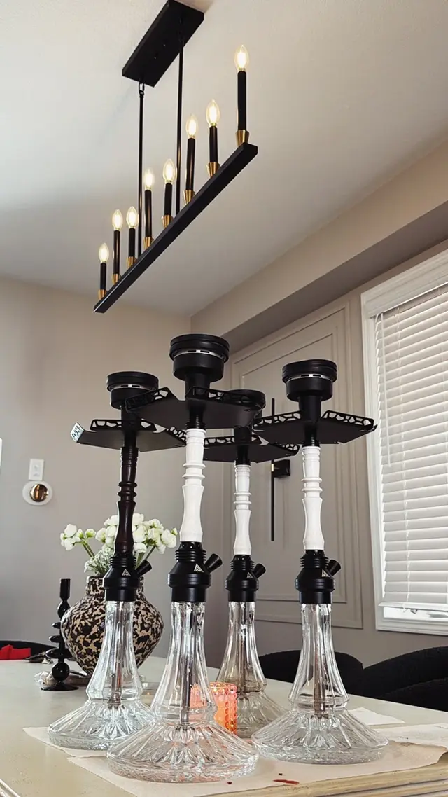 Four hookahs set up along a dining table under a candle-bar chandelier for a house party