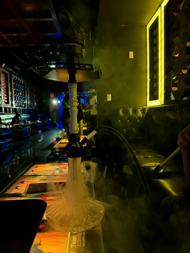 Hookah set up on the bar of a low-lit lounge, smoke drifting across the counter