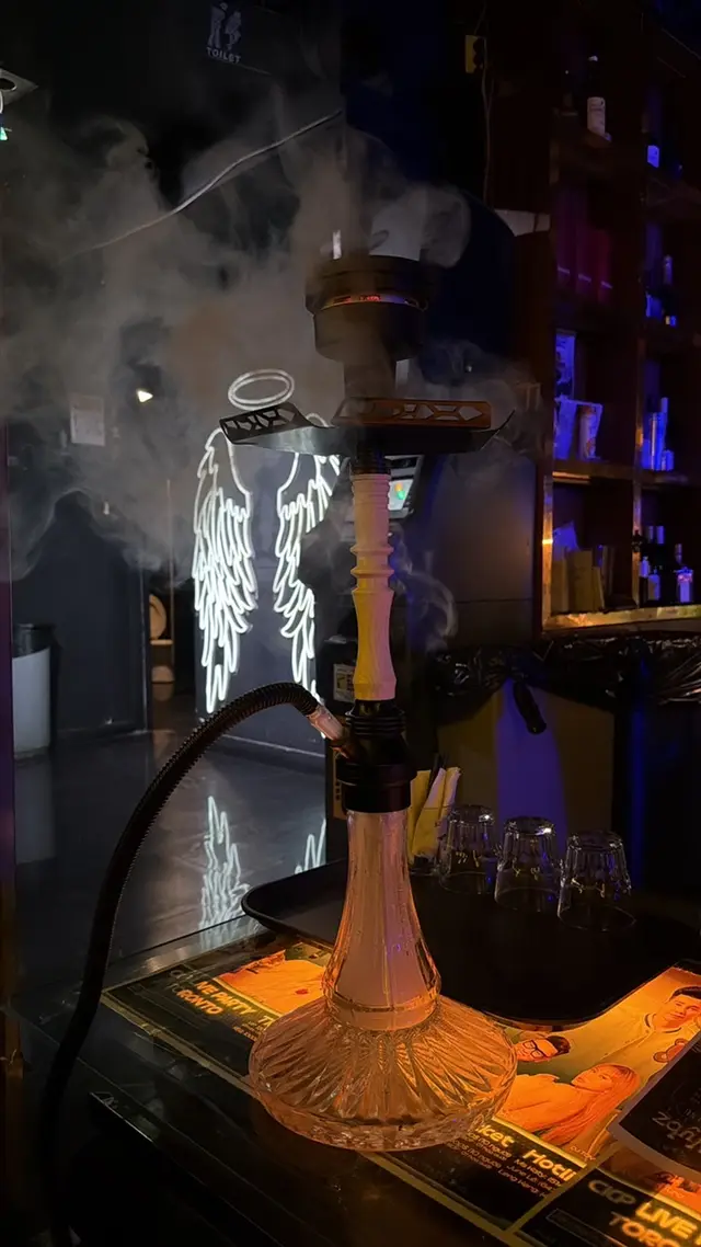 Hookah on a bar counter with glassware behind it