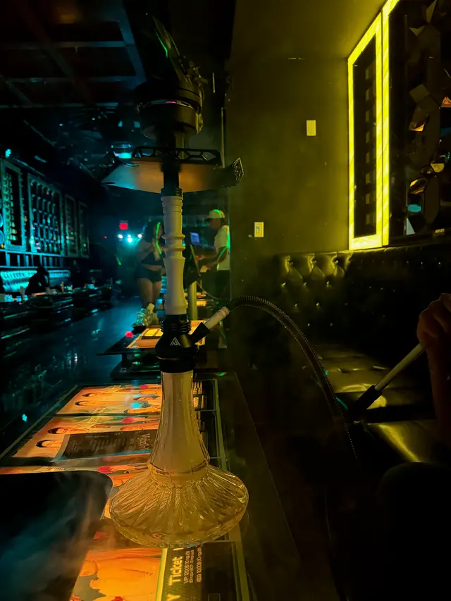 Hookah on a lounge bar under teal and yellow light