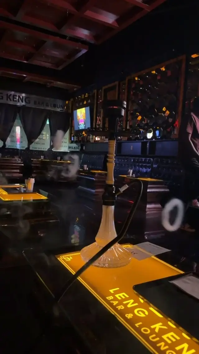 Hookah running on the bar of a low-lit lounge, smoke rolling across the counter
