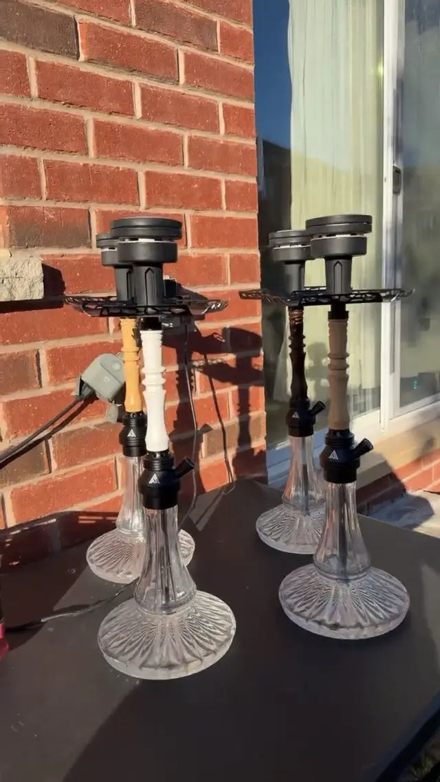 Four hookahs set up outdoors against a brick wall
