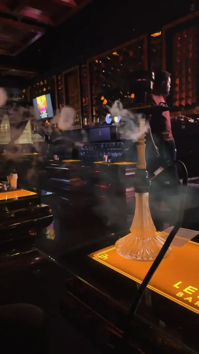 Hookah running on the bar of a low-lit lounge, smoke rolling across the counter