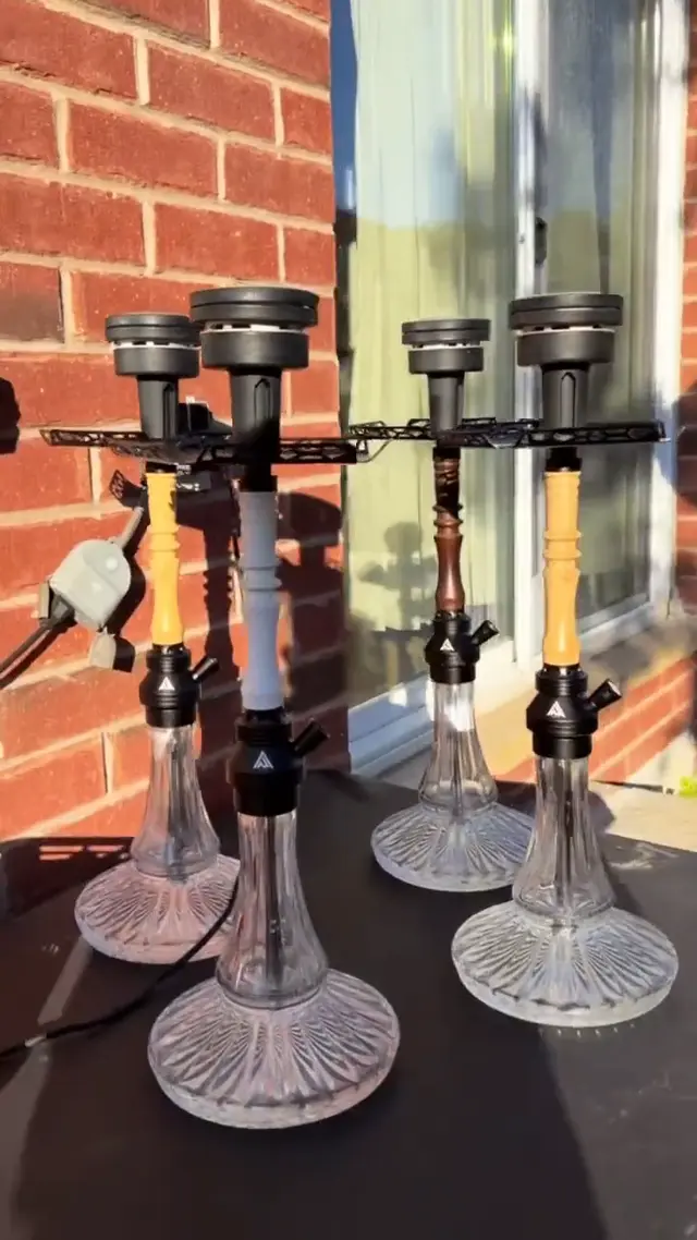 Four hookahs set up outdoors against a brick wall