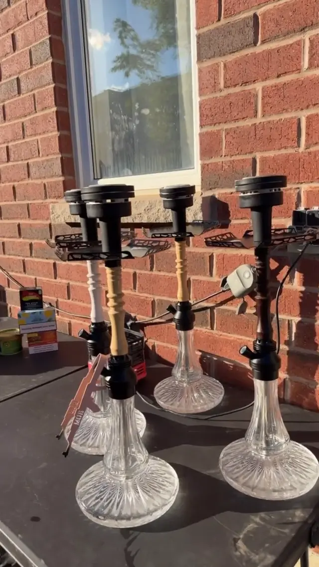 Four hookahs set up outdoors against a brick wall